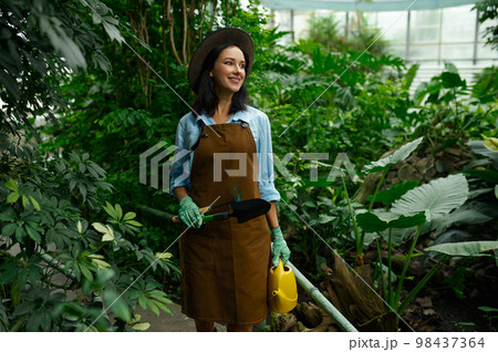 Young woman gardener working in botanic garden Young woman gardener working in botanic garden 98437364
