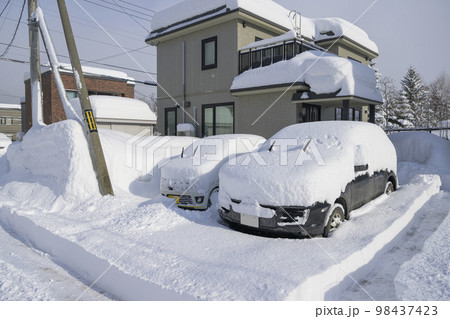 大雪で埋まる家と車 98437423