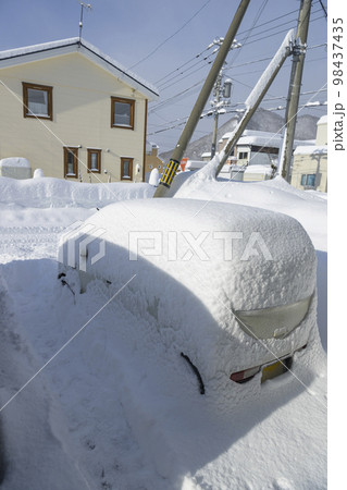 大雪で埋まる駐車場の車 98437435