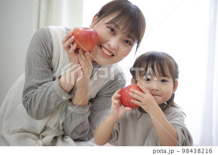 リンゴを持つ親子 98438216