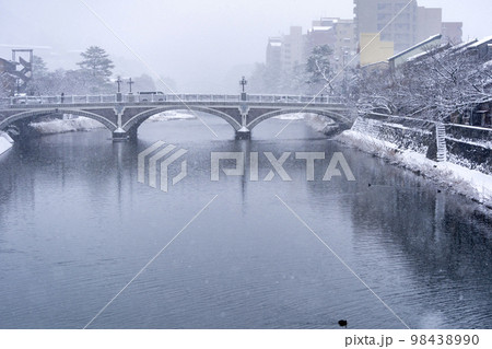冬の金沢・雪が降り積もる浅野川と浅野川大橋 98438990