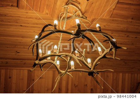 Chandelier on the ceiling made of deer antlers. A light bulb in the shape of a candle. 98441004