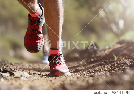 Trail running athlete exercising for fitness and health outdoors on mountain pathway, closeup of running shoes in action 98443296