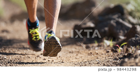 Trail running athlete exercising for fitness and health outdoors on mountain pathway, closeup of running shoes in action 98443298
