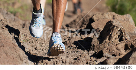 Trail running athlete exercising for fitness and health outdoors on mountain pathway, closeup of running shoes in action 98443300