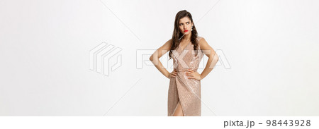 Christmas party and celebration concept. Full length of attractive brunette in elegant dress, red lipstick, looking displeased and angry left, standing over white background 98443928