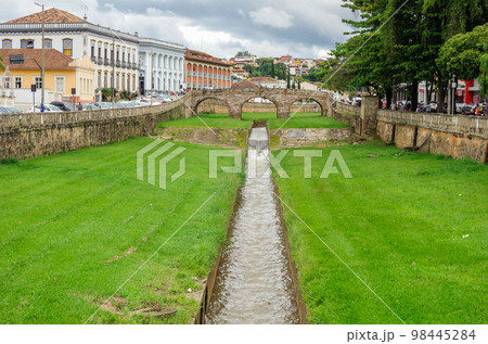 narrow stream, old bridge and ancient architecture of Sao Joao del Rei, Minas Gerais state, Brazil 98445284