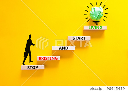 Stop existing start living symbol. Concept words Stop existing and start living on wooden blocks. Beautiful yellow table yellow background. Business Stop existing start living concept. Copy space. Stop existing start living symbol. Concept words Stop existing and start living on wooden blocks. Beautiful yellow table yellow background. Business Stop existing start living concept. Copy space. 98445459