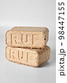 Two wooden briquettes (ruf type) on white background. 98447155