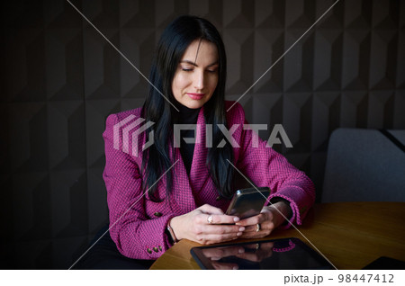 Beautiful confident Caucasian 40-45 years old woman, successful businesswoman in formal wear, chatting on mobile phone while waiting for colleagues and business partners for meeting in office interior Beautiful confident Caucasian 40-45 years old woman, successful businesswoman in formal wear, chatting on mobile phone while waiting for colleagues and business partners for meeting in office interior 98447412