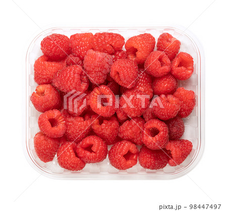 Whole fresh raspberries, in a clear plastic punnet, from above. Ripe, red and sweet fruits of Rubus idaeus, the cultivated European raspberry. Organic and vegan fruits. Isolated, close-up, food photo. 98447497