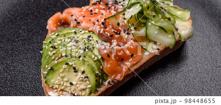 Fresh tasty sandwich with salmon, avocado and sesame and flax seeds 98448655