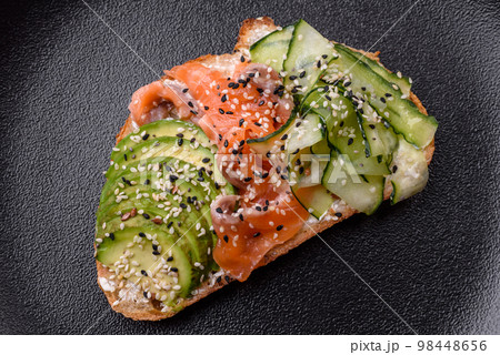Fresh tasty sandwich with salmon, avocado and sesame and flax seeds 98448656