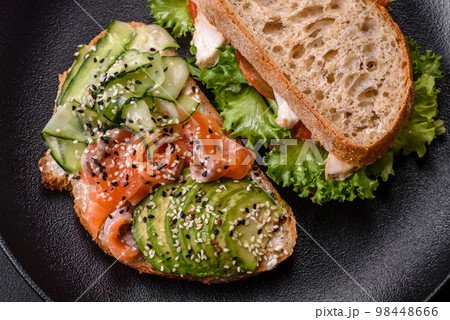 Fresh tasty sandwich with salmon, avocado and sesame and flax seeds 98448666