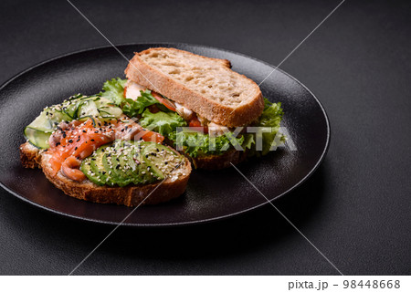Fresh tasty sandwich with salmon, avocado and sesame and flax seeds 98448668