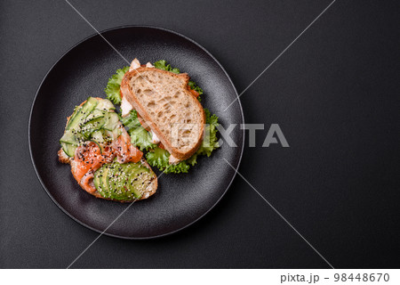 Fresh tasty sandwich with salmon, avocado and sesame and flax seeds 98448670