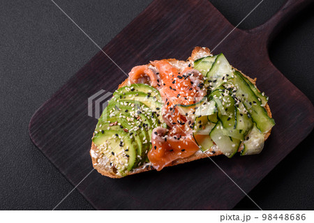Fresh tasty sandwich with salmon, avocado and sesame and flax seeds 98448686