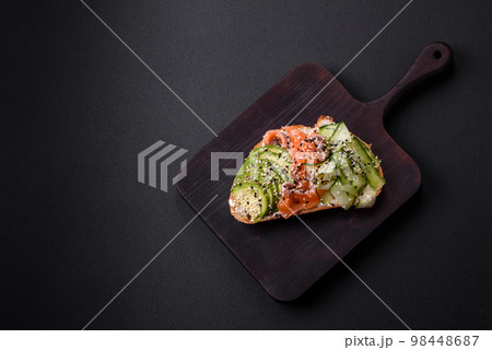 Fresh tasty sandwich with salmon, avocado and sesame and flax seeds 98448687
