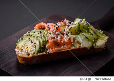 Fresh tasty sandwich with salmon, avocado and sesame and flax seeds 98448688