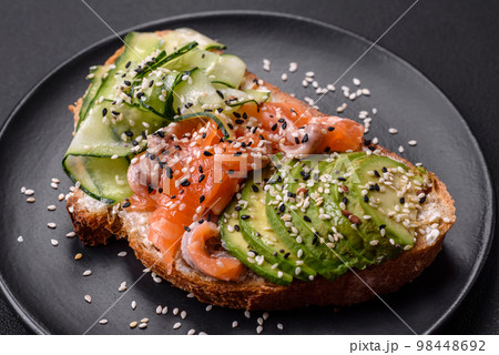 Fresh tasty sandwich with salmon, avocado and sesame and flax seeds 98448692
