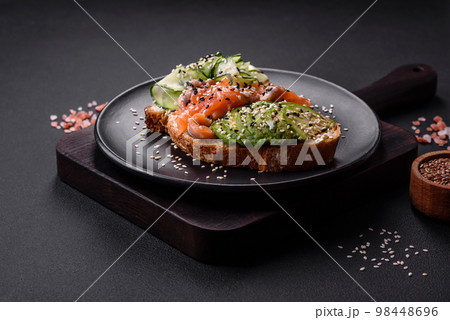 Fresh tasty sandwich with salmon, avocado and sesame and flax seeds 98448696