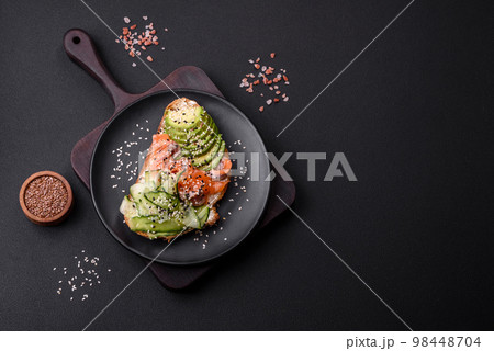 Fresh tasty sandwich with salmon, avocado and sesame and flax seeds 98448704