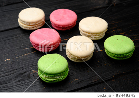Sweet colorful macarons, on black wooden table background 98449245