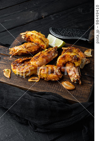 Sticky Mango Prawns or shrimps, on wooden board, on black wooden table background Sticky Mango Prawns or shrimps, on wooden board, on black wooden table background 98449410
