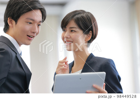 タブレットを見ながら打ち合わせるビジネスパーソン男女_クローズアップ3 タブレットを見ながら打ち合わせるビジネスパーソン男女_クローズアップ3 98449528