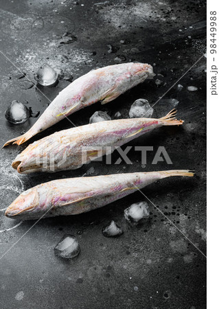 Frozen mullet or sultanka fish, on black dark stone table background 98449988