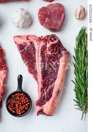 Dry-aged Raw T-bone or porterhouse beef meat Steak, on white stone  background, top view flat lay Dry-aged Raw T-bone or porterhouse beef meat Steak, on white stone  background, top view flat lay 98450029