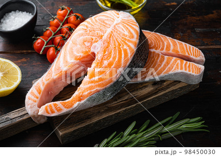 Slice of red fish salmon with herbs, on old wooden table 98450030