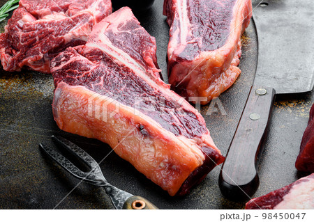 T bone steak. Organic raw Tbon beef marbled meat, on old dark rustic background T bone steak. Organic raw Tbon beef marbled meat, on old dark rustic background 98450047