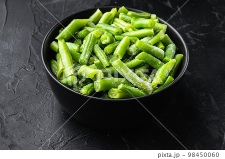 Green beans. Fresh frozen beans for salad, cooking or raw vegan food, in bowl, on black stone background 98450060