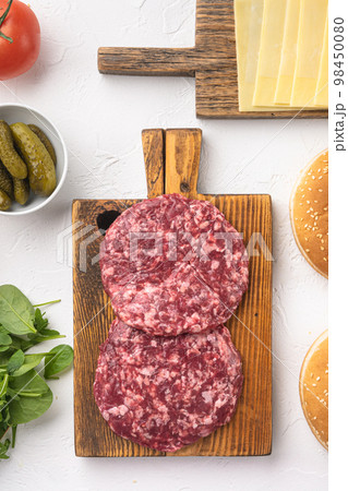 Fresh raw minced homemade farmers beef burgers cutlets, on white stone  background, top view flat lay 98450080