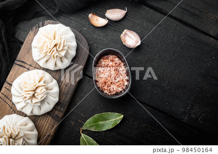 Khinkali, Georgian dumplings, traditional Georgian cuisine, on black wooden table background, top view flat lay, with copy space for text 98450164