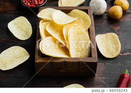 Salty potato chips snack , on old dark  wooden table 98450245