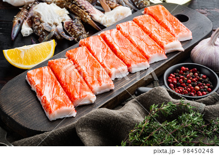 Fresh Crab meat stick surimi with blue swimming crab, on dark wooden background 98450248