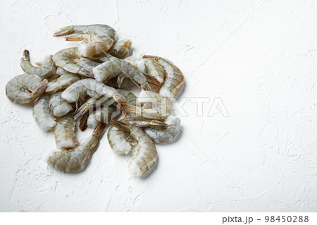 Raw fresh uncooked prawns shrimps, on white stone  surface, with copy space for text 98450288