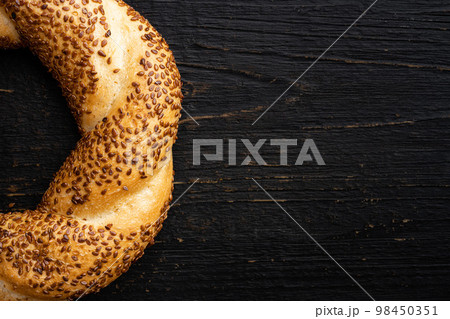 Traditional turkish simit bagels with sesame, on black wooden table background, top view flat lay, with copy space for text Traditional turkish simit bagels with sesame, on black wooden table background, top view flat lay, with copy space for text 98450351