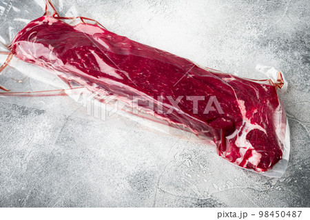 Fillet beef vacuum bag for sous vide, on gray stone background, with copy space for text Fillet beef vacuum bag for sous vide, on gray stone background, with copy space for text 98450487
