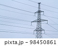 New large mast of an air power line close up, high voltage electricity pylon with thick wires and insulators, blue sky on background. Traditional energy. Electric power concept. 98450861