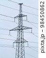 New large mast of an air power line close up, high voltage electricity pylon with thick wires and insulators, blue sky on background. Traditional energy. Electric power concept. 98450862