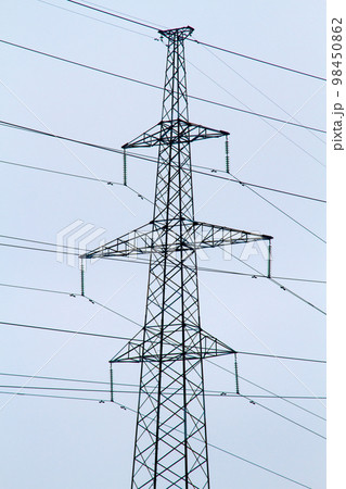 New large mast of an air power line close up, high voltage electricity pylon with thick wires and insulators, blue sky on background. Traditional energy. Electric power concept. New large mast of an air power line close up, high voltage electricity pylon with thick wires and insulators, blue sky on background. Traditional energy. Electric power concept. 98450862