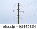 New large mast of an air power line close up, high voltage electricity pylon with thick wires and insulators, blue sky on background. Traditional energy. Electric power concept. 98450864