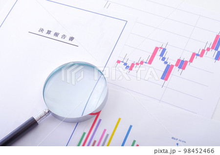 決算報告書と株価チャートと虫メガネ 決算報告書と株価チャートと虫メガネ 98452466