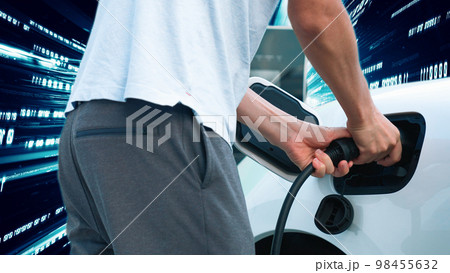 Progressive man charge electric car with technology background of binary code. 98455632