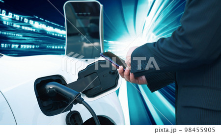 Progressive man charge electric car with technology background of binary code. 98455905