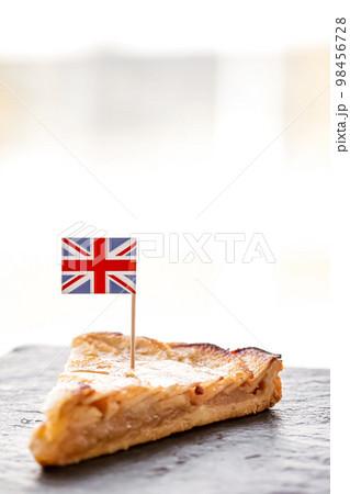 United Kingdom, dessert and bakery, slice of apple tart with British flag, close-up 98456728