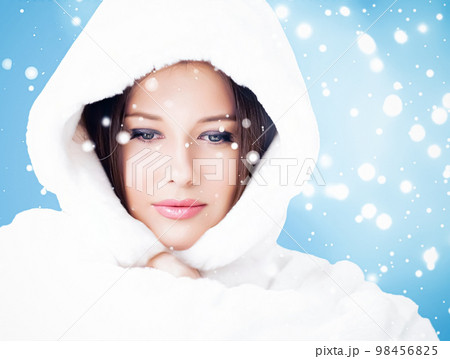 Happy holidays, beauty and winter fashion, beautiful woman wearing white fluffy fur coat, snowing snow on blue background as Christmas, New Year and holiday lifestyle portrait style 98456825